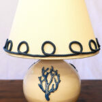 Lampada da tavolo in ceramica con decoro in rilievo e paralume in tessuto